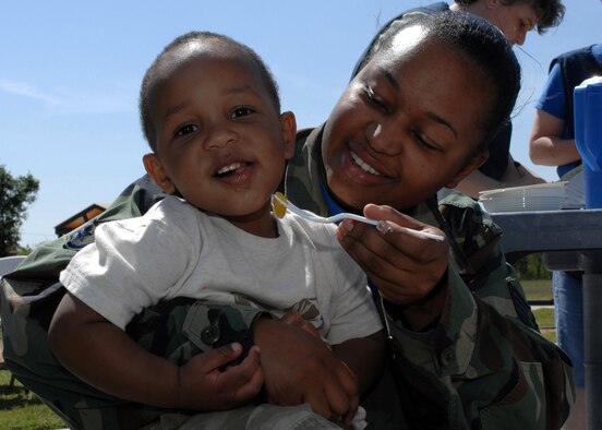 Javon Williams, 23 months, eats and plays with his mom, Staff Sgt. Sparkle Williams, Det. 14, at the seventh annual CDC BBQ April 20. The BBQ was held during the Month of the Military Child to allow the parents to eat with their children during the duty day. (U.S. Air Force photo by Senior Airman Courtney Garrard)