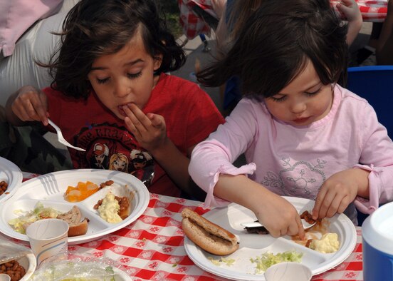 Noli Jones, 4, and her sister Dawn, 2, chow down on hamburgers and beans during the Child Development Center BBQ April 20. The BBQ is one of the many events that were held in April during the Month of the Military Child. (U.S. Air Force photo by Senior Airman Courtney Garrard)