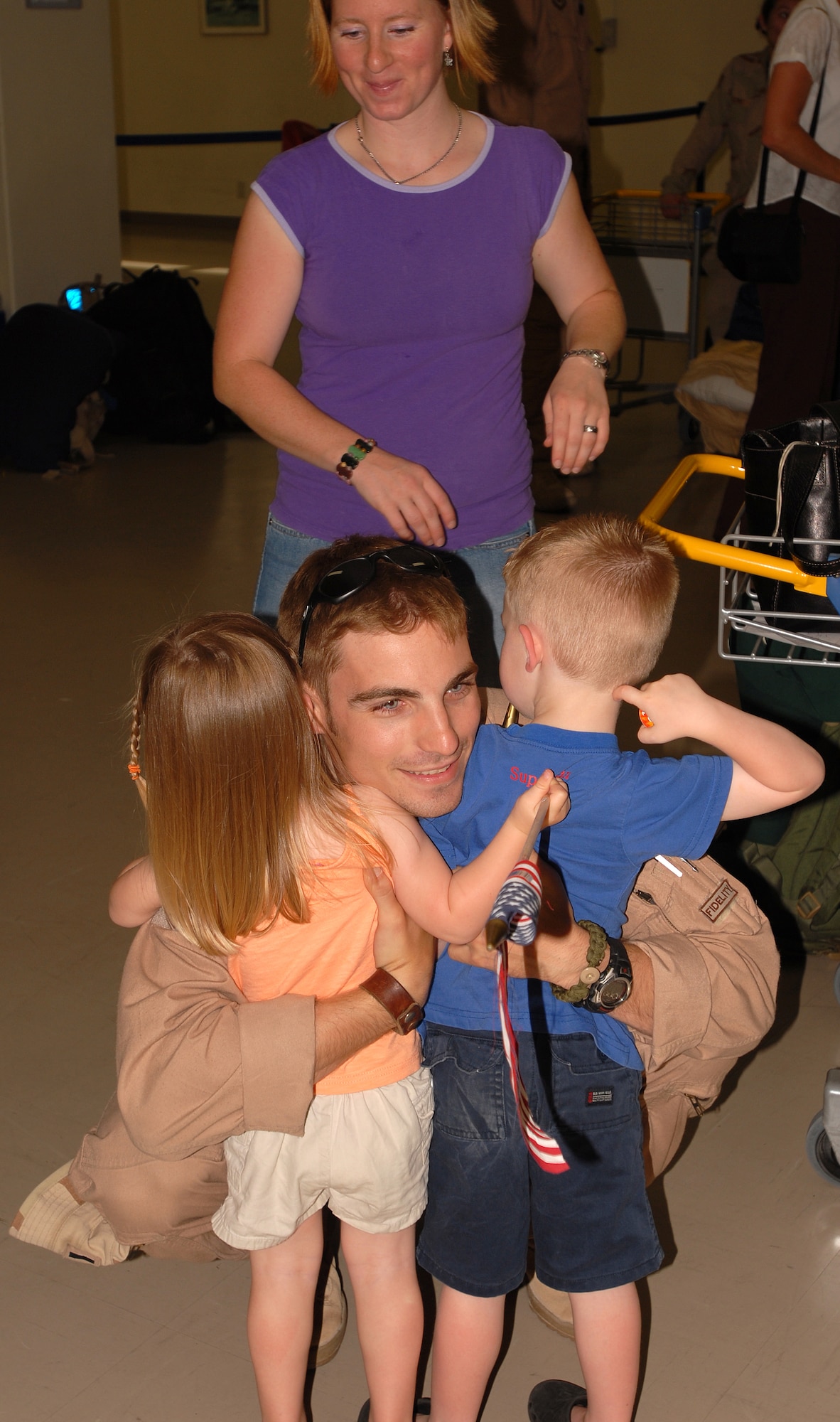 First Lt. Aaron Croft, an HH-60 helicopter pilot for the 33rd Rescue Squadron at Kadena Air Base, Japan, hugs his children after returning from a 120-day deployment to Kandahar, Afghanistan.  While in Afghanistan, the 33rd Rescue Squadron saved 116 lives and flew more than 200 sorties.  Dozens of Airmen from the 718th Aircraft Maintenance Squadron and the 18th Equipment Maintenance Squadron were also deployed with the 33rd RQS.  (U.S. Air Force photo by Airman 1st Class Ryan Ivacic)