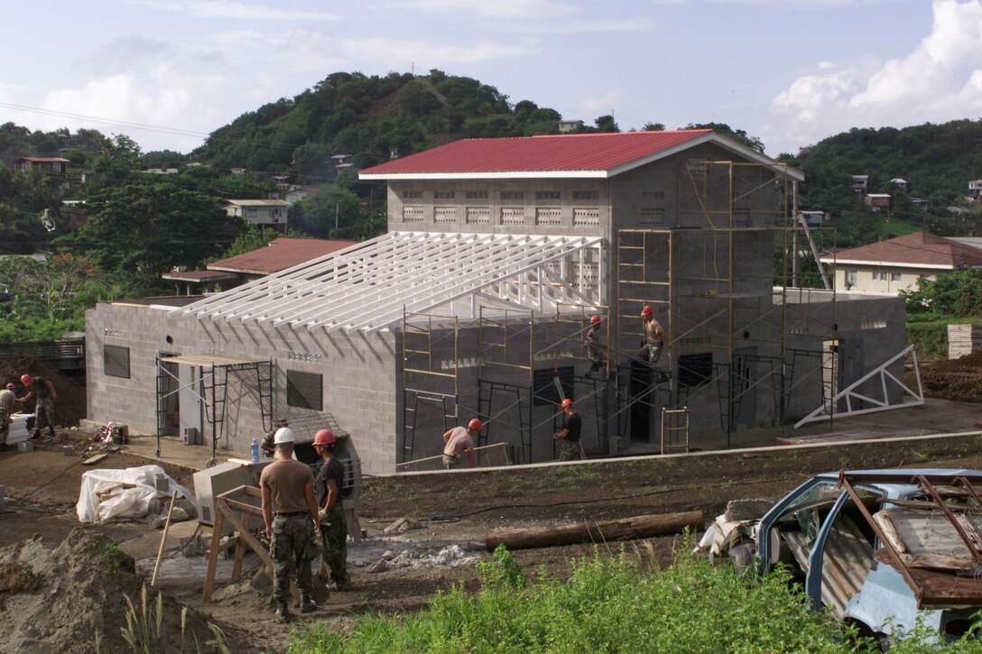 Members of the 820th Red Horse Squadron of Nellis Air Force Base, Nev., and the Marines' 8th Engineer Support Battalion of Camp Lejeune, N.C., erect the Mont Tout Community Center on the island of Grenada during a U.S. Southern Command New Horizons 2000 exercise. The project last July was intended to improve the readiness of U.S. engineering, medical and support forces while responding to host-nation civic needs. Red Horse is an Air Force acronym for Rapid Engineer Deployable Heavy Operational Repair Squadron, Engineer. Photo by Tech. Sgt. Jonathan F. Doti, USAF