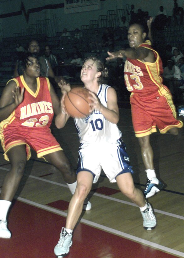 Air Force guard 2nd Lt. Kallie Quinn sets for a shot between the tight defense of Marines Lance Cpl. Keena Brock (23) and Gunnery Sgt. Annette Mitchell during a Women’s Armed Forces Basketball Championship game at Randolph Air Force Base, Texas. The Marines beat the Air Force 68-54 to capture second place in the tournament. Quinn is from Ellsworth Air Force Base, S.D.; Brock, from Marine Corps Air Station Futenma, Japan; and Mitchell, Marine Corps Air Station Beaufort, S.C. Photo by David Terry. 