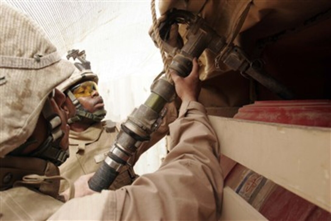 U.S. Marine Corps Cpl. Jesse Smith and Lance Cpl. Cory Roundtree fuel a generator at Camp India, Iraq, on April 26, 2007.  Both Marines are assigned to Transportation Support Company, Combat Logistics Battalion 6.  