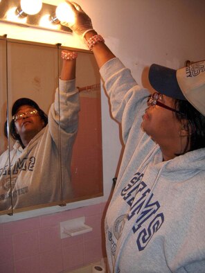 CAPITOL HEIGHTS, Md. -- Tech. Sgt. Brenda Simms, 69th Aerial Port Squadron transportation specialist, installs a new lightbulb in a home during "Christmas in April" April 28. The program helps local residents through volunteer participation in cleaning, repairs, yardwork, painting or any other needs the homeowner may have. Typical resident candidates for home makeovers are elderly, disabled, low-income or a combination of all. This year, the 459th Air Refueling Wing sent more than 30 volunteers to help improve an area home. The 459th ARW is a Reserve component of the USAF. (U.S. Air Force photo/Staff Sgt. Amaani Lyle)