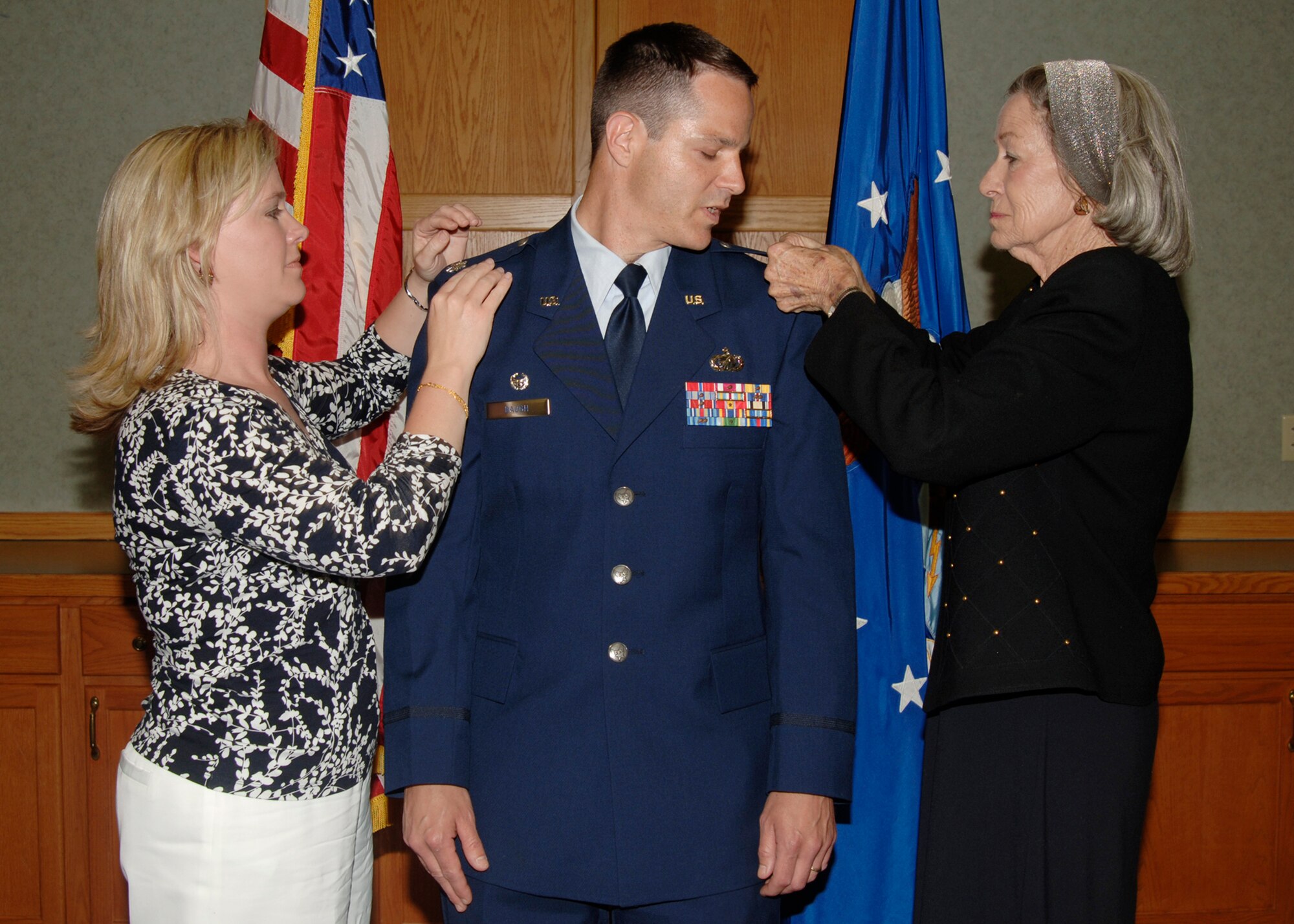 Maj. Marvin Baugh, Deputy Commander, 22nd Mission Support Group deputy commander, watches his mother, Rose Baugh Bacon, pin on his new rank of lieutenant colonel, with his wife, Julia, during his promotion ceremony, April 30, at the base chapel. (photo by Airman 1st Class Jessica Corob)