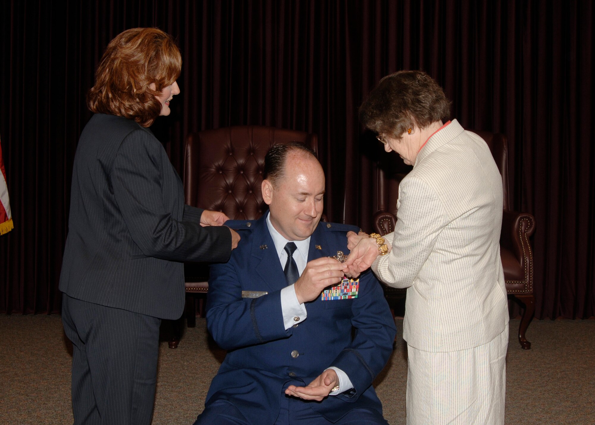 Lt. Col. Stuart Shaw, 22nd Operations Group vice commander, pin on colonel during his promotion ceremony, May 1, at the 384th Air Refueling Squadron auditorium.  His wife, Penny, and mother, Mary Shaw, do the honors. (photo by Airman 1st Class Jessica Corob)