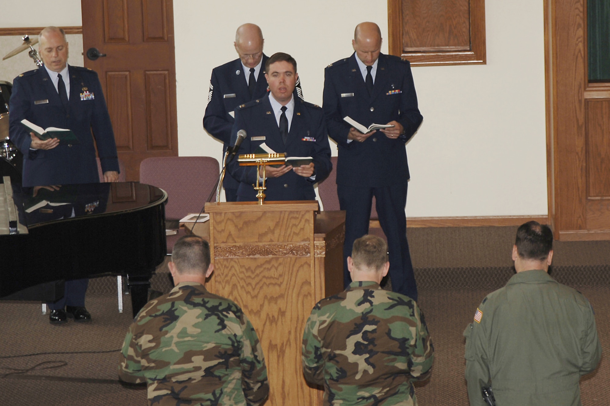Chaplain (Capt.) Kevin Hudson leads a congregation in chorus at the base chapel, April 26, for the memorial service honoring retired Staff Sgt. John Heath who passed away from Lou Gehrig’s disease, April 17, at a hospital in Ellenton, Fla., where he lived.  The former McConnell member was an aircraft maintainer from the 22nd Aircraft Maintenance Squadron. (Photo by Airman 1st Class Laura Suttles)