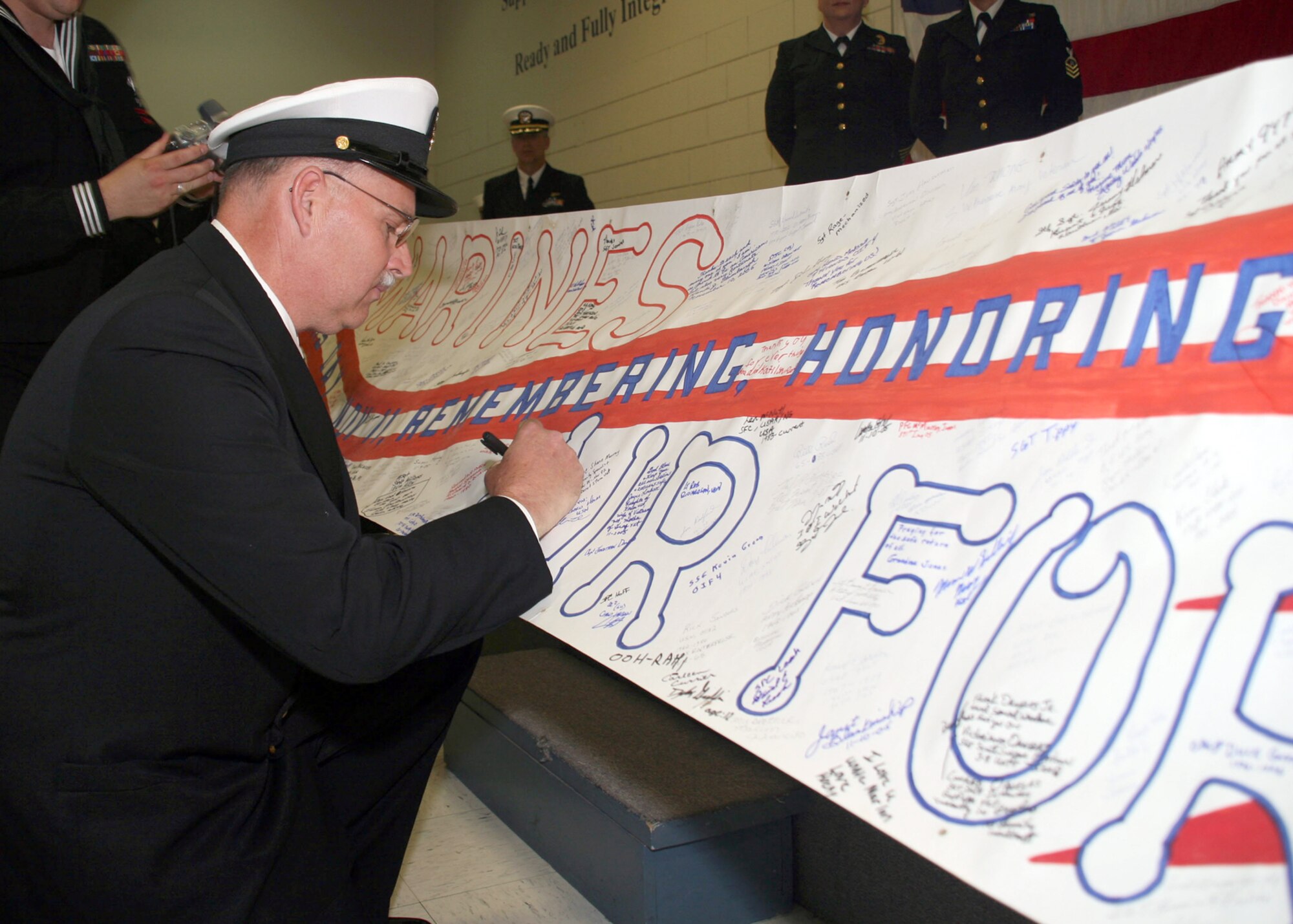 NAVY OPERATIONAL SUPPORT CENTER, Kan. -- Navy Master Chief Petty Officer Ricke Whiteside signs a traveling banner as a tribute to veterans around the globe during his retirement ceremony April 15 at the Navy Operational Support Center, Wichita. Chief Whiteside retired after completing 30 years of naval service. Chief Whiteside currently resides in El Dorado, Kan., and is employed by the El Dorado Fire Department as a fire captain. (Navy photo by Petty Officer 2nd Class Ron Trevino)


