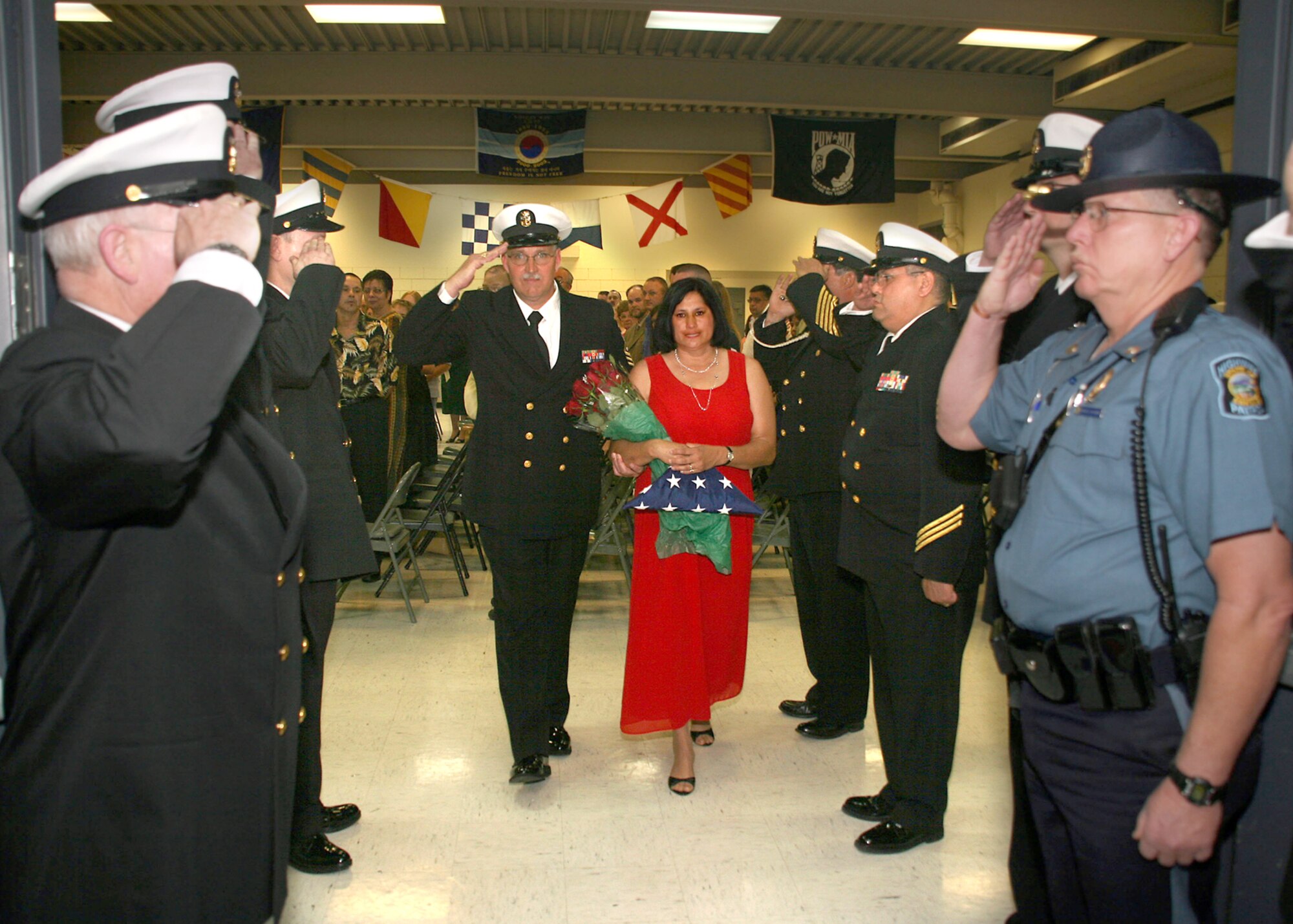 NAVY OPERATIONAL SUPPORT CENTER, Kan. -- Navy Master Chief Petty Officer Ricke Whiteside and his wife,Trina, render honors as they pipe through side boys at the conclusion of Chief Whiteside’s traditional Navy retirement ceremony held April 15 at the Navy Operational Support Center, Wichita. Master Chief Whiteside retired after completing 30 years of naval service. Chief Whiteside currently resides in El Dorado, Kan., and is employed by the El Dorado Fire Department as a fire captain. (Navy photo by Petty Officer 2nd Class Ron Trevino)


