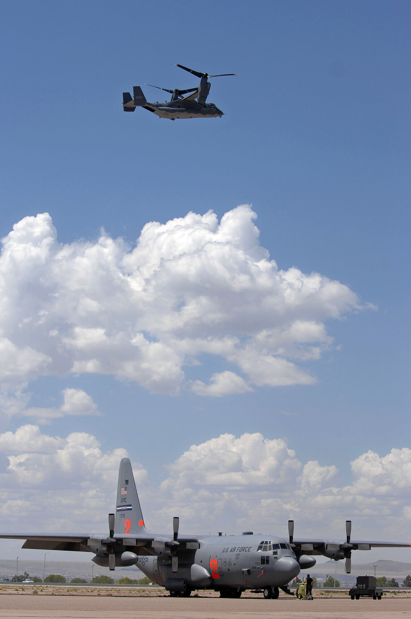 A CV-22 Osprey flies over a C-130 Hercules and the U.S. Forest Service's Albuquerque Air Tanker Base as C-130 aircrews from the Air National Guard and Air Force Reserve Command began arriving April 30 for Modular Airborne Fire Fighting System training at the air tanker base in New Mexico. The CV-22 is based at the 58th Special Operations Wing from Kirtland Air Force Base, N.M., and the C-130 is from the 302nd Airlift Wing at Peterson Air Force Base, Colo. (U.S. Air Force photo/Tech. Sgt. Rick Sforza) 
