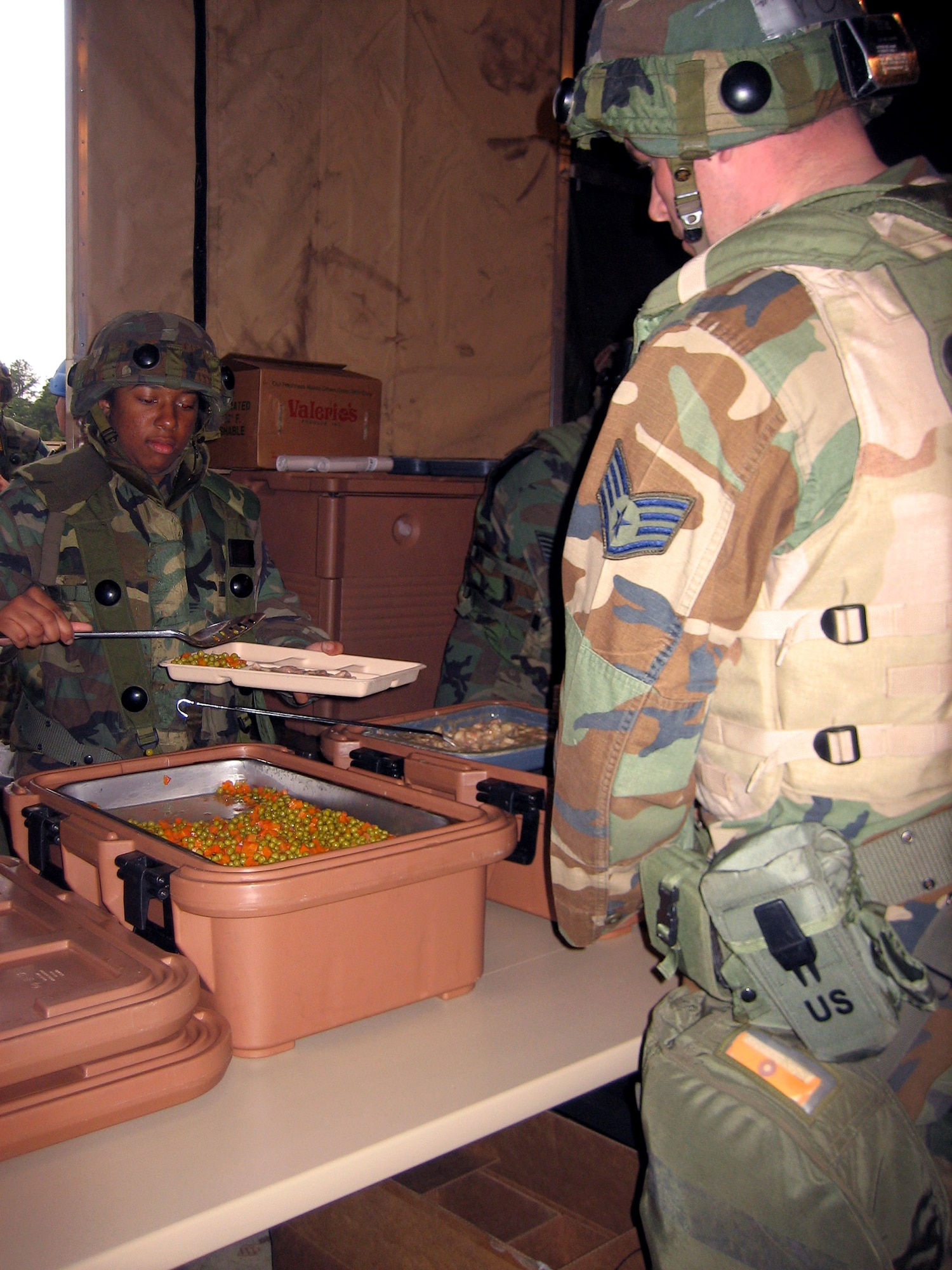 Services Airmen deployed to Air Force exercise Eagle Flag 07-4 serve up food to exercise participants April 25 during an evening meal at Naval Air Engineering Station at Lakehurst, N.J. Services members prepared the food in the Single Pallet Expeditionary Kitchen, or SPEK. During each Eagle Flag exercise, more than 30 services Airmen deploy to support the exercise operated by the Air Force Expeditionary Center's 421st Combat Training Squadron. (U.S. Air Force photo/Senior Airman Jared Marquis) 