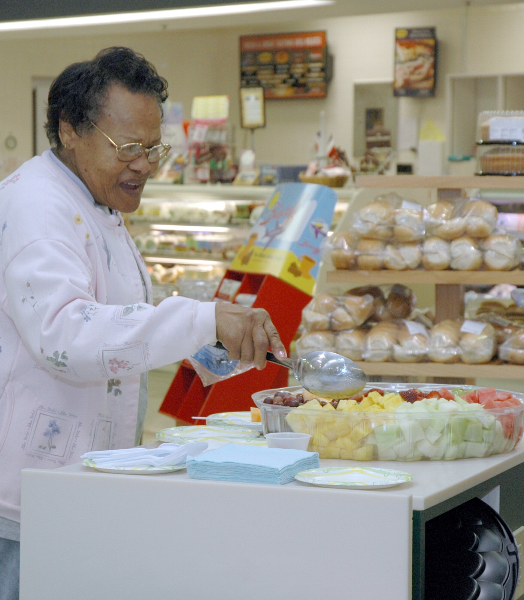 Cleo Miles helps herself to some complimentary fruit before starting her shopping at the commissary Saturday.
