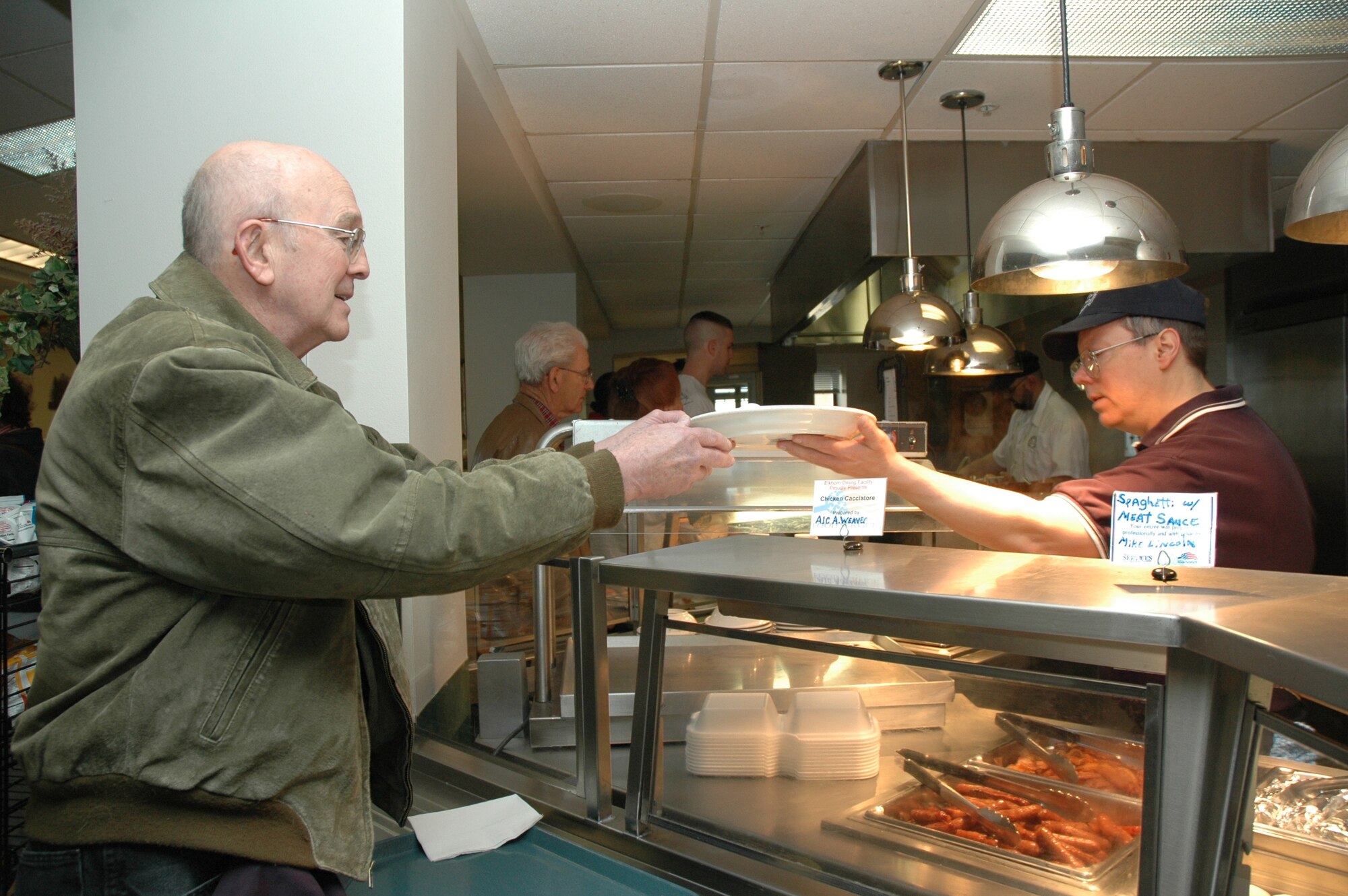 Elkhorn Diner employee Pete McDermott hands a visiting retiree his breakfast.