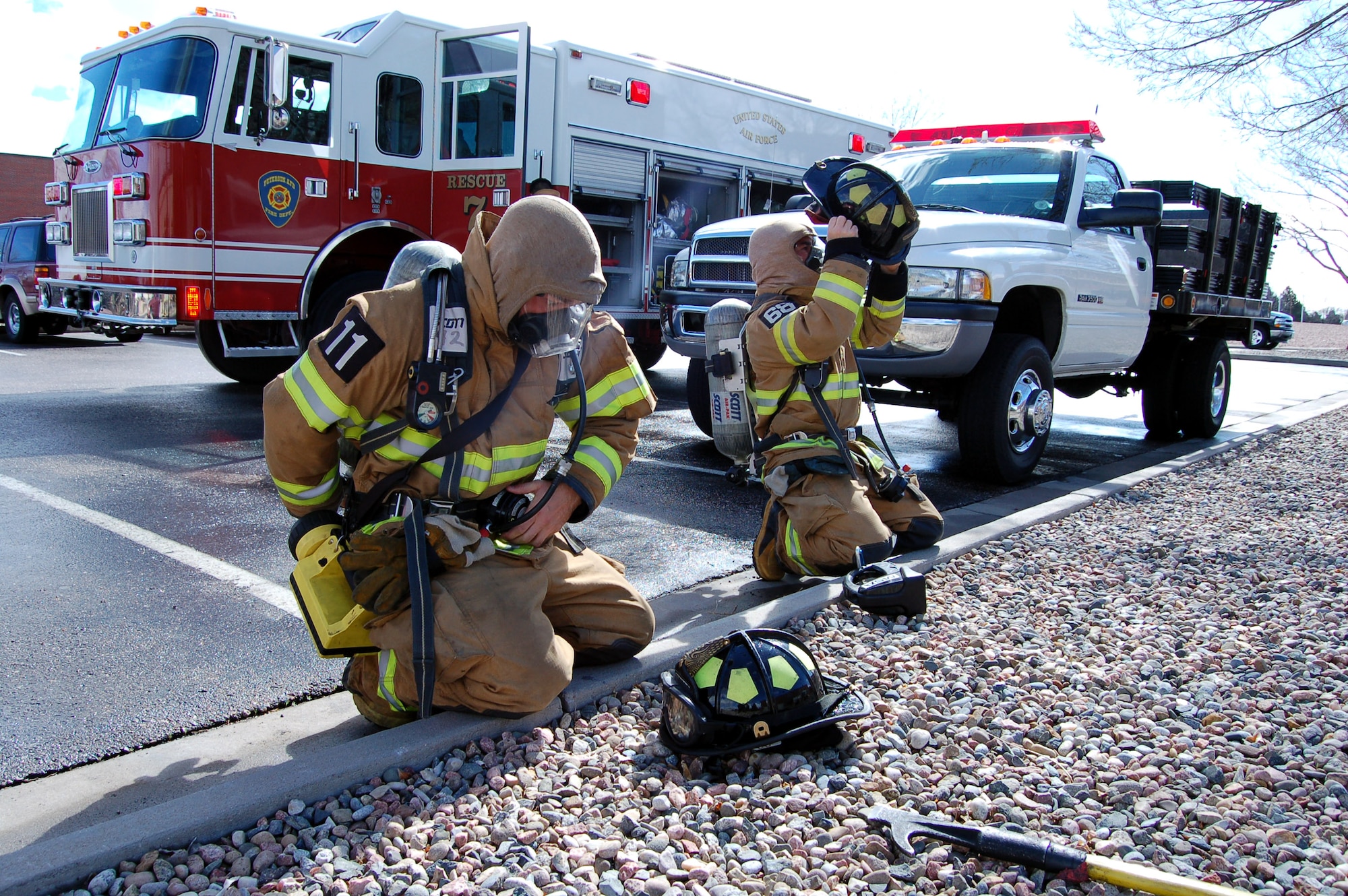 Senior Airman Jesse Simons (left) and Tech. Sgt. Chancy Cruger don their self contained breathing apparatuses during a firefighting exercise April 10 at Peterson Air Force Base, Colo. The training is essential to keeping the firefighters sharp and ready to perform their duties in a moment's notice. (U.S. Air Force photo/Staff Sgt. Jeremy Larlee) 
