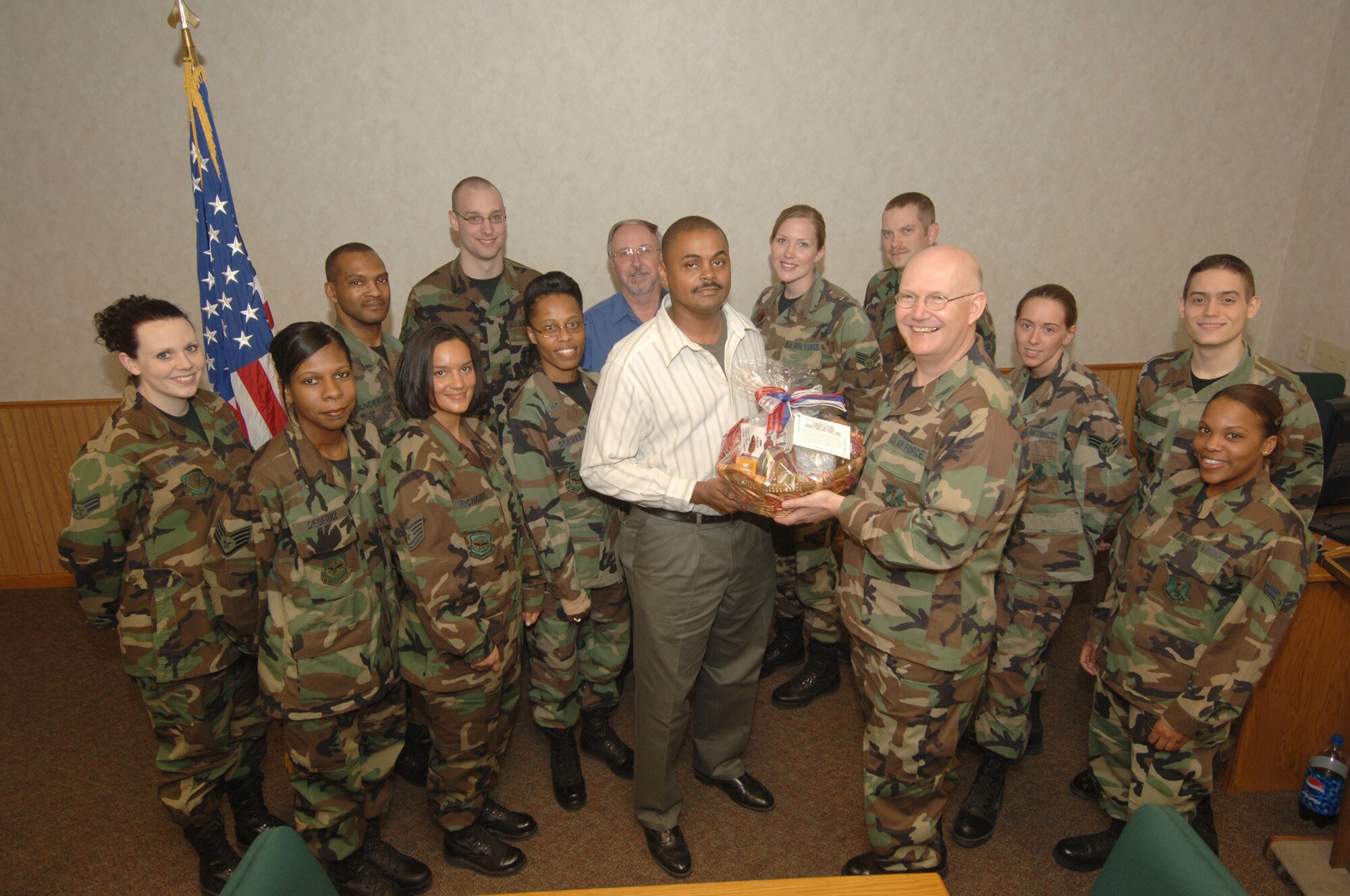 GRAND FORKS AIR FORCE BASE, N.D. -- Col. Robert Quinn, 319th Medical Group commander, presents a token of appreciation to Mr. Terence Beasley, 319 MDG other health insurance representative for his dedication to the third party collection program. This year, the 319 MDG has achieved its fiscal year 2007 annual TPC reimbursement goal of $135,000 within the first six months of this fiscal year, surpassing the total collections for the entire previous year. The Grand Forks AFB third party collections program, which includes "yellow card" verification, is the venue for obtaining these reimbursements.  The money collected assists with funding medical facility projects, equipment and supply purchases, and training opportunities--directly contributing to the enhancement of patient care for all Grand Forks Air Force Base beneficiaries.   