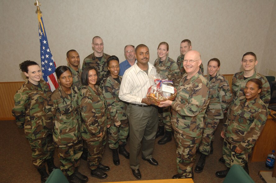 GRAND FORKS AIR FORCE BASE, N.D. -- Col. Robert Quinn, 319th Medical Group commander, presents a token of appreciation to Mr. Terence Beasley, 319 MDG other health insurance representative for his dedication to the third party collection program. This year, the 319 MDG has achieved its fiscal year 2007 annual TPC reimbursement goal of $135,000 within the first six months of this fiscal year, surpassing the total collections for the entire previous year. The Grand Forks AFB third party collections program, which includes "yellow card" verification, is the venue for obtaining these reimbursements.  The money collected assists with funding medical facility projects, equipment and supply purchases, and training opportunities--directly contributing to the enhancement of patient care for all Grand Forks Air Force Base beneficiaries.   