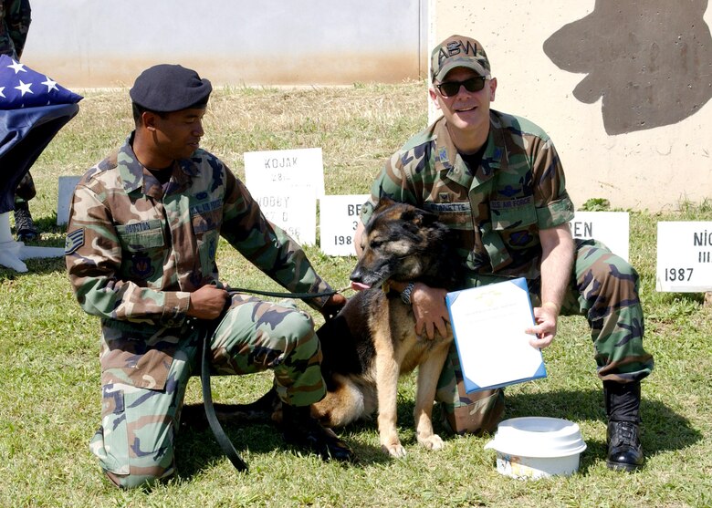 Col. "Tip" Stinnette (right) and Staff Sgt. Kennith Houston present Brosky a retirement certificate April 27 at Incirlik Air Base, Turkey. Brosky has worked on Incirlik AB for the past nine years as a patrol/explosive detection military working dog. Colonel Stinnette is the 39th Air Base Wing commander, and Sergeant Houston is a military working dog handler. (U.S. Air Force photo/Airman 1st Class Tiffany Colburn) 