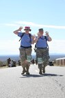 Army Spc. Allison Wilson (right), 314th Military Intelligence Battalion, and Senior Airman Elizabeth Elliot, 93rd Intelligence Squadron, Lackland Air Force Base, Texas, show off that they have completed the first ten miles of the memorial march on March 25 at White Sands Missile Range, N.M. The two walked together the whole time, each one boosting the spirit of the other and driving forward. (USAF photo by Army Spc. Tim Luukkonen)