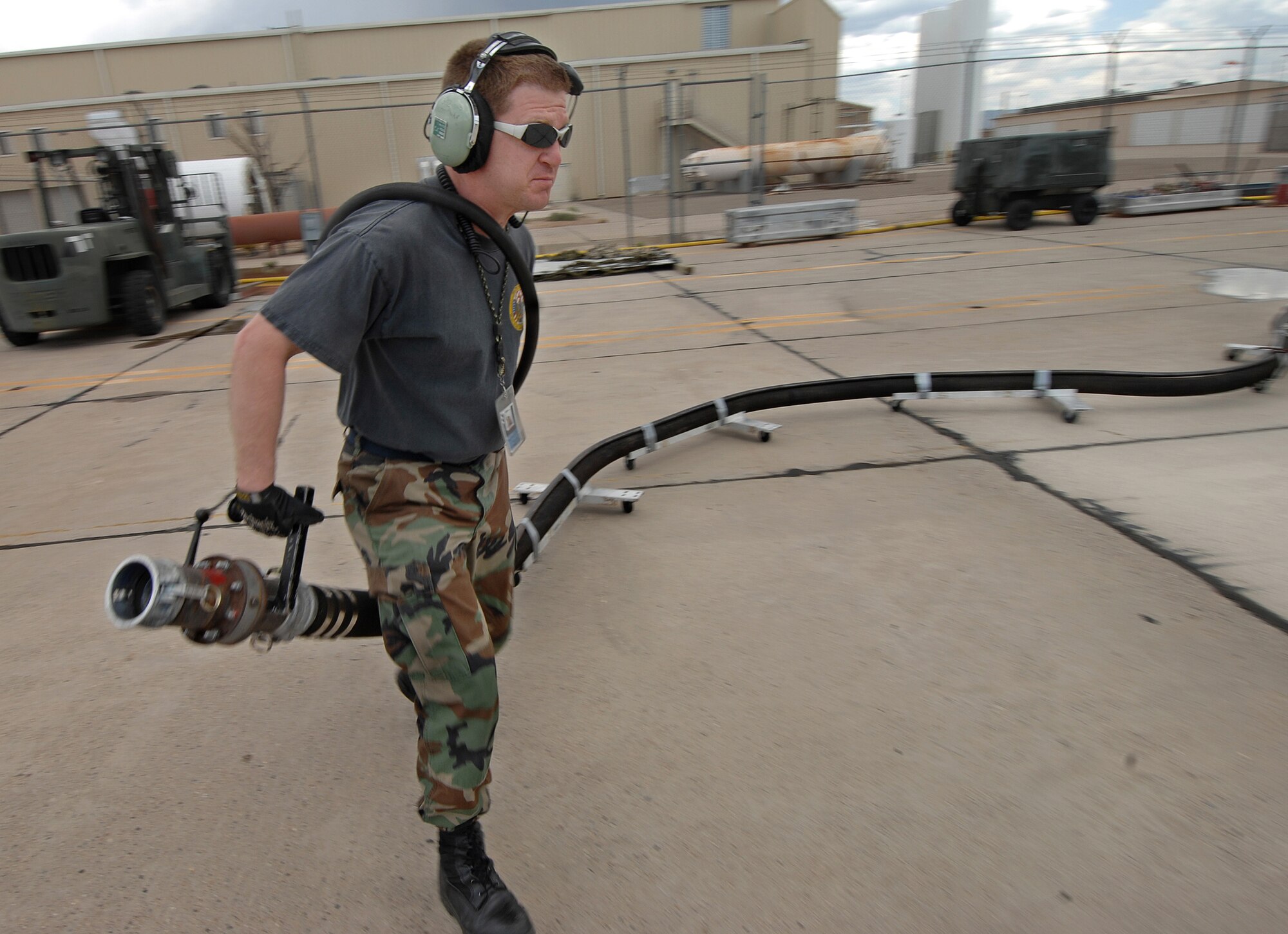 Master Sgt. Tracey White from the 302nd Maintenance Squadron drags a Modular Airborne Fire Fighting System hose to a waiting 302nd Airlift Wing C-130 on May 1, 2007, to charge the aircraft's MAFFS tanks with water and air.  C-130 aircrews from the Air Force Reserve Command unit based at Peterson Air Force Base, Colo., and Air National Guard units trained at the U.S. Forest Service's Albuquerque Air Tanker Base in New Mexico. (U.S. Air Force photo/Tech. Sgt. Rick Sforza)