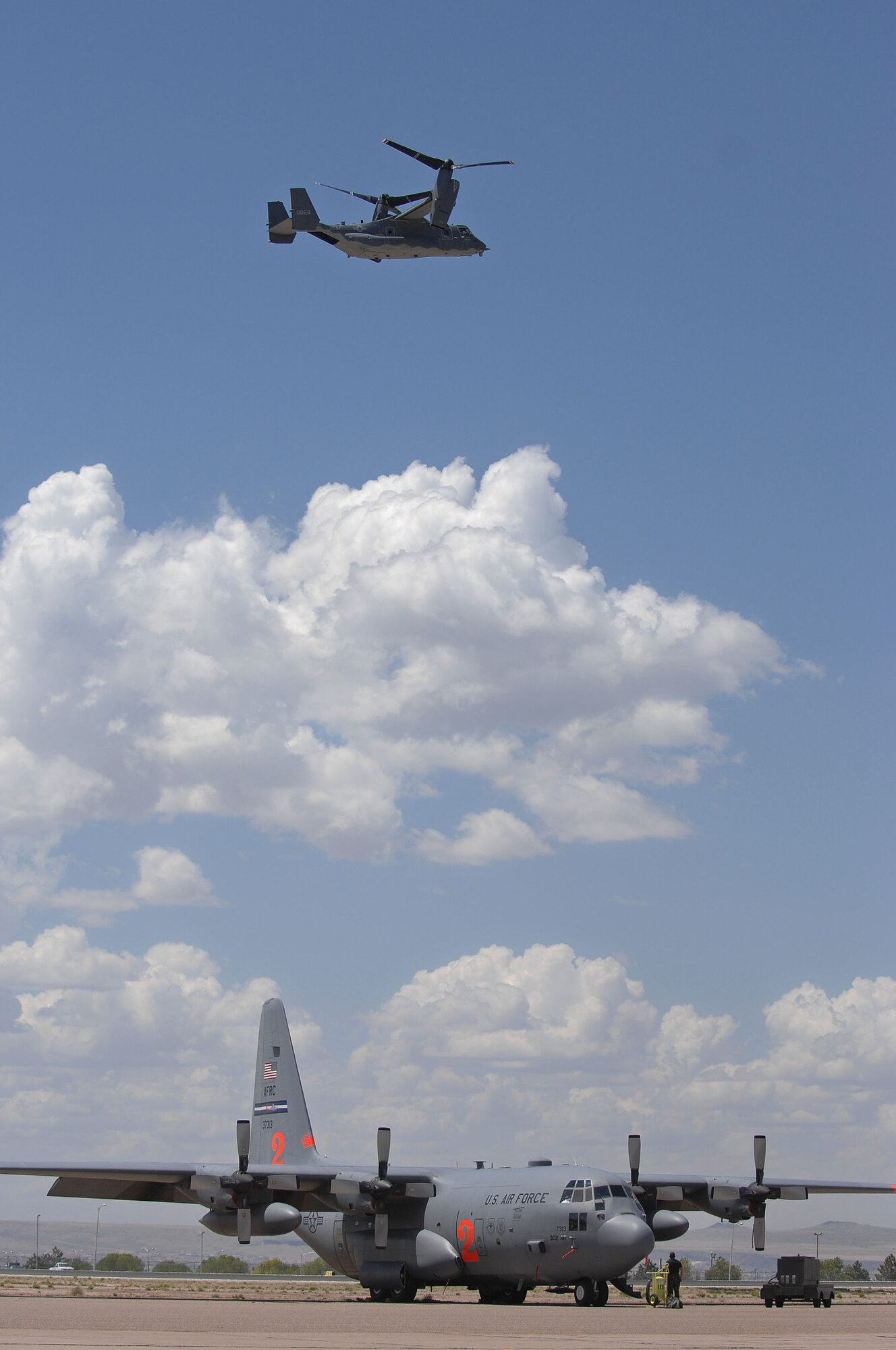 A CV-22 Osprey from the 58th Special Operations Wing, Kirtland Air Force Base, N.M., flies over a C-130 from the 302nd Airlift Wing and the U.S. Forest Service's Albuquerque Air Tanker Base as C-130 aircrews from the Air National Guard and Air Force Reserve Command began arriving April 30, 2007, for Modular Airborne Fire Fighting System training at the air tanker base in New Mexico.  (U.S. Air Force photo/Tech. Sgt. Rick Sforza)
