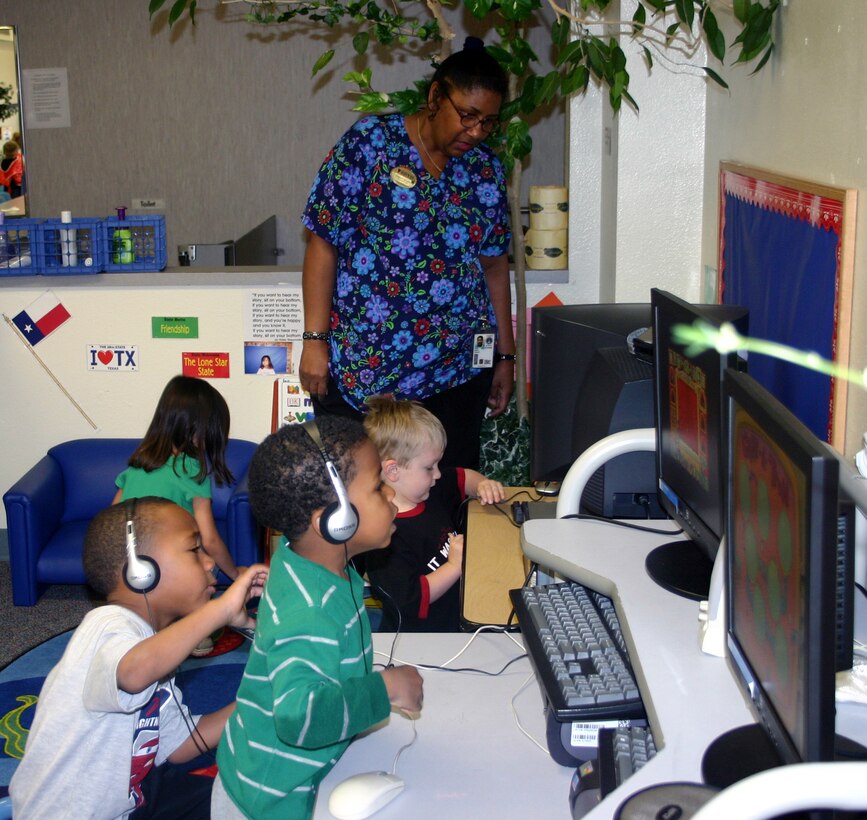 Cheryl Moore observes as the preschoolers in Room 10 play the "Magic School Bus" computer game at the Child Development Center. (U.S. Air Force photo/Staff Sgt. Tonnette Thompson)