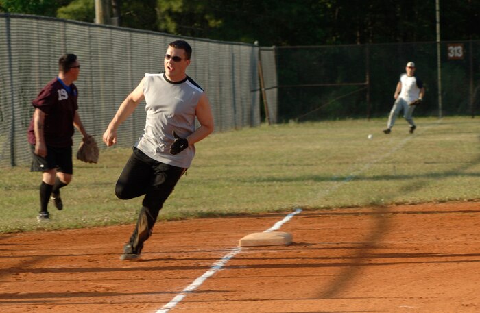 Tech. Sgt. Jamey Elms Maintenance Squadron 1 rounds third and heads for home as Maintenance Operations Squadron attempts to get the ball back into play.  (U.S. Air Force photo/Staff Sgt. April Quintanilla)