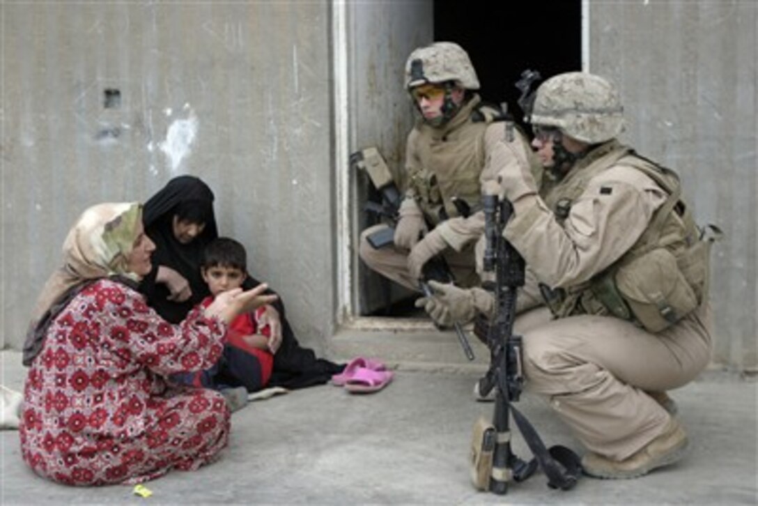 Two U.S. Marines speak with local Iraqi women during a security patrol in Saqlawiyah, Iraq, on April 28, 2007.  The Marines are assigned to Weapons Platoon, Fox Company, 2nd Battalion, 7th Marine Regiment.  
