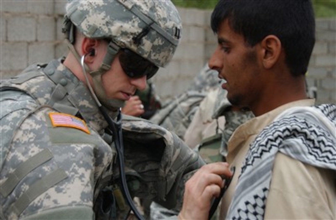 U.S. Army Capt. Damon Cudlhy examines an Iraqi man during a combined medical assistance mission with the Iraqi army near Mahmudiyah, Iraq, on April 22, 2007.  Cudlhy is assigned to Charlie Company, 2nd Battalion, 10th Infantry Regiment, Brigade Support Detachment, 10th Mountain Division.  