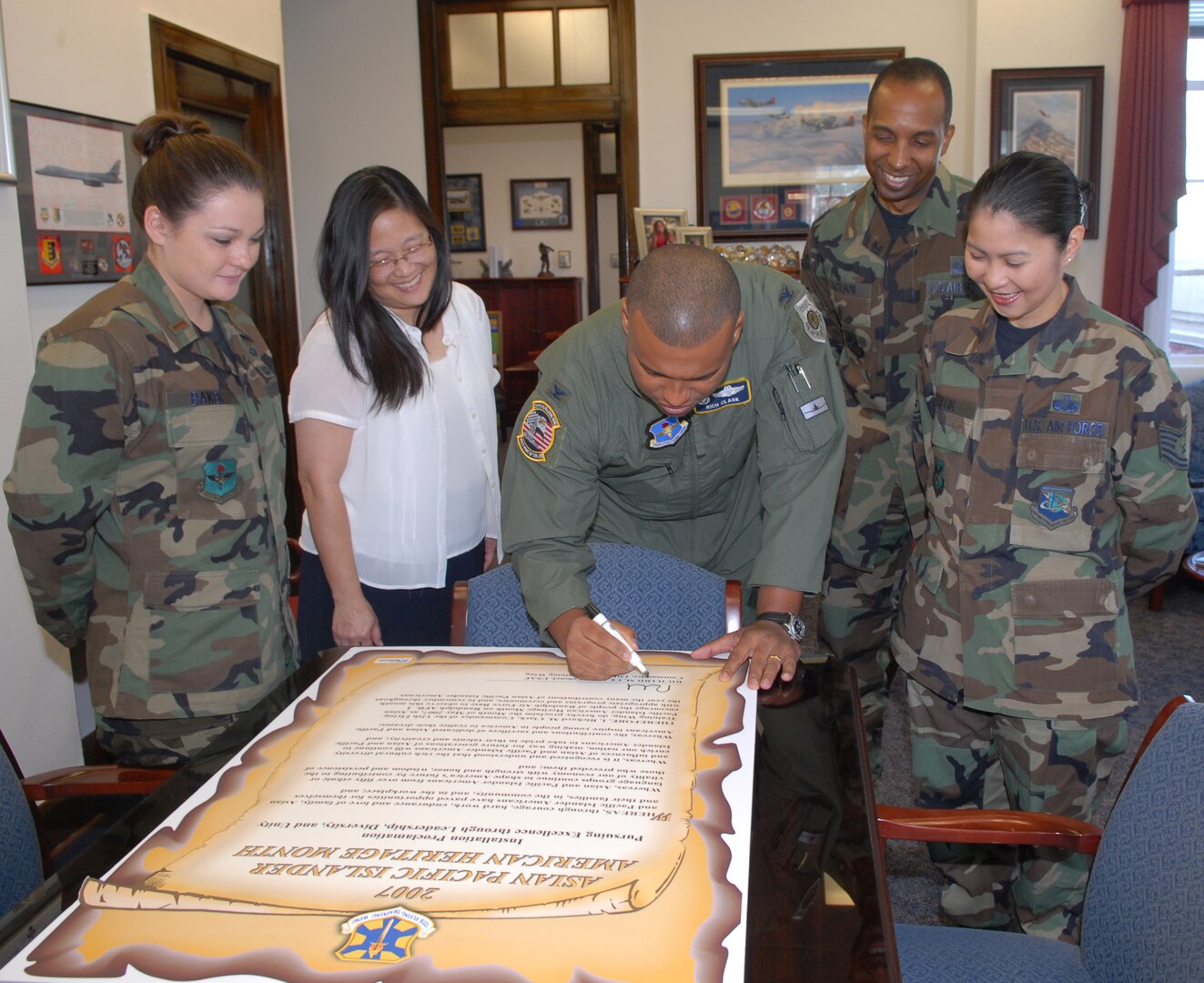 Col. Richard Clark, (center) 12th Flying Training Wing commander, signs the Asian Pacific American Heritage Month proclamation April 26 as members of the APAHM organizational committe look on. (From left to right) 2nd Lt. Elizabeth Baker, 12th FTW project officer, Kathryn Baker, 5K run coordinator, Master Sgt. Aaron Jackson, 12th FTW Military Equal Opportunity advisor, and Tech Sgt. Myrla Kiluk, Committee co-chairman. There are numerous events planned for the month in celebration of the diversity of Randolph's community. For more information on the events planned for the month, call Lieutenant Baker at 652-5181 or Sergeant Kiluk at 652-2265. 