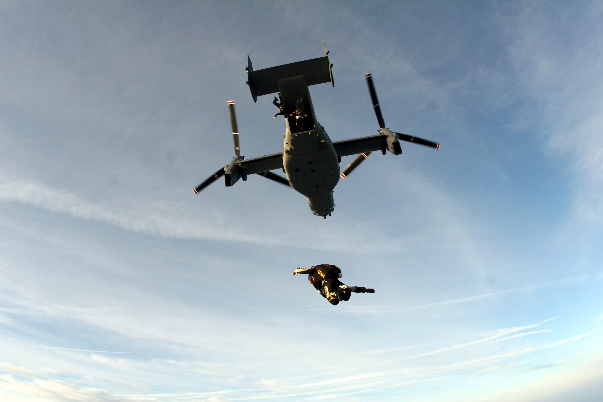 Tandem jumpers from the U.S. Army Golden Knights parachute team freefall below an Air Force Special Operations Command CV-22 Osprey over MacDill Air Force Base, Fla., April 26.  The Osprey and aircrew are from the 8th Special Operations Squadron at Hurlburt Field, Fla. (Department of Defense photo)