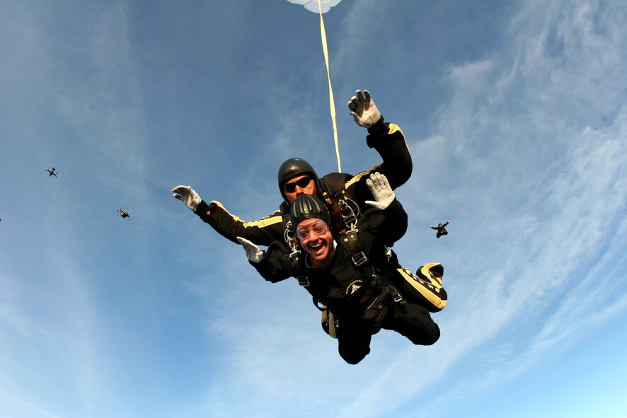 Melissa Bunting, an executive producer for a Tampa, Fla., radio station, freefalls over nearby MacDill Air Force Base April 26 during a tandem jump with Sgt. 1st Class Michael Elliott of the U.S. Army Golden Knights parachute team. The pair jumped from an Air Force Special Operations Command CV-22 Osprey (far left) from the 8th Special Operations Squadron at Hurlburt Field, Fla. (Department of Defense photo) 