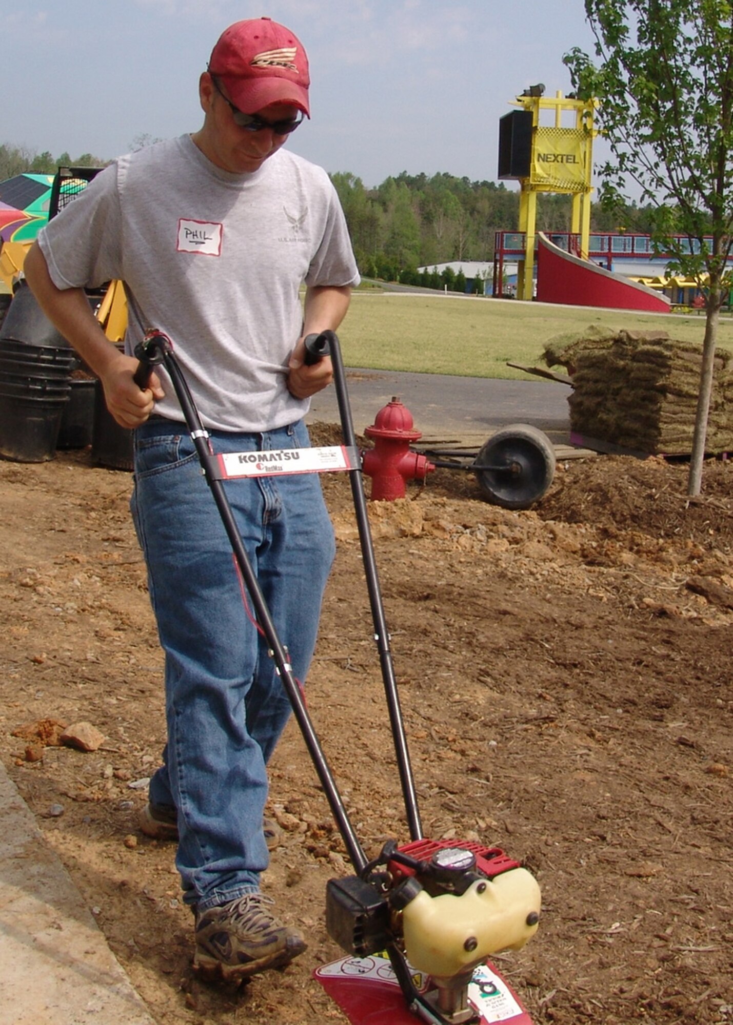 Tech. Sgt. Phillip Howell, 337th Recruiting Squadron enlisted accessions recruiter from Salisbury, N.C., tills soil around the Victory Junction Gang Camp’s tree house April 26, preparing the area for fellow volunteers to lay sod. The camp provides a medically sound environment for children with chronic or serious illnesses to play. With one day’s work, 27 members of the 337th RCS helped complete a week’s worth of landscape projects. (U.S. Air Force photo by Tech. Sgt. Michael Asdel)