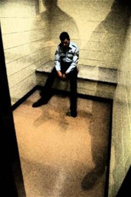 An Airman sits in a holding cell at a security forces squadron after being convicted of wrongfully using drugs.  (U.S. Air Force photo illustration by Staff Sgt. Austin M. May)