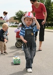 Justin Harter, 3, keeps his "Uncle Sam" hat from falling over his eyes as he pulls his float in the Month of the Military Child Shoebox Parade on April 27 around the Family Child Care Office at Kenly and Selfridge Avenues on Lackland Air Force Base, Texas. He is the son of Staff Sgt. Ryan and Lisa Harter. "It was an awesome turnout," said Tina Matthews,  Family Child Care Support Group president and event planner. She said the parade included 25 to 30 floats. "The children enjoyed pulling their floats, and especially making them at home with their parents," she said. "We had great support from parents and providers as well." (USAF photo by Robbin Cresswell)