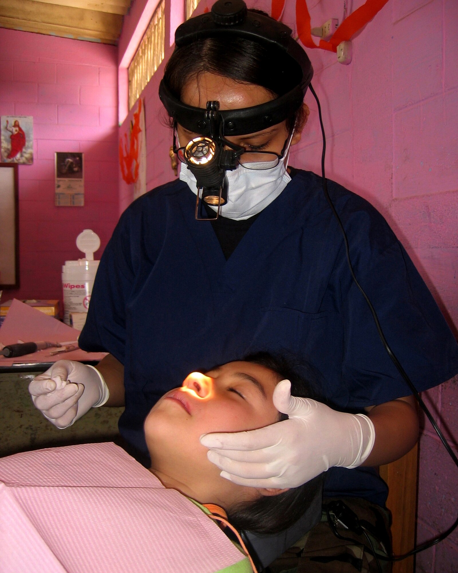 Airman 1st Class Laura Valenzuela De La Hoya, a dental technician from Vandenberg AFB, Calif., completes an examination on a Guatemalan child.  Airman Valenzuela De La Hoya and Capt. (Dr.) Seth Briggs, also from Vandenberg, extracted 871 teeth and restored another 85 during the 10-day humanitarian mission to various regions of Guatemala in the last days of April. (U.S. Air Force Courtesy Photo)