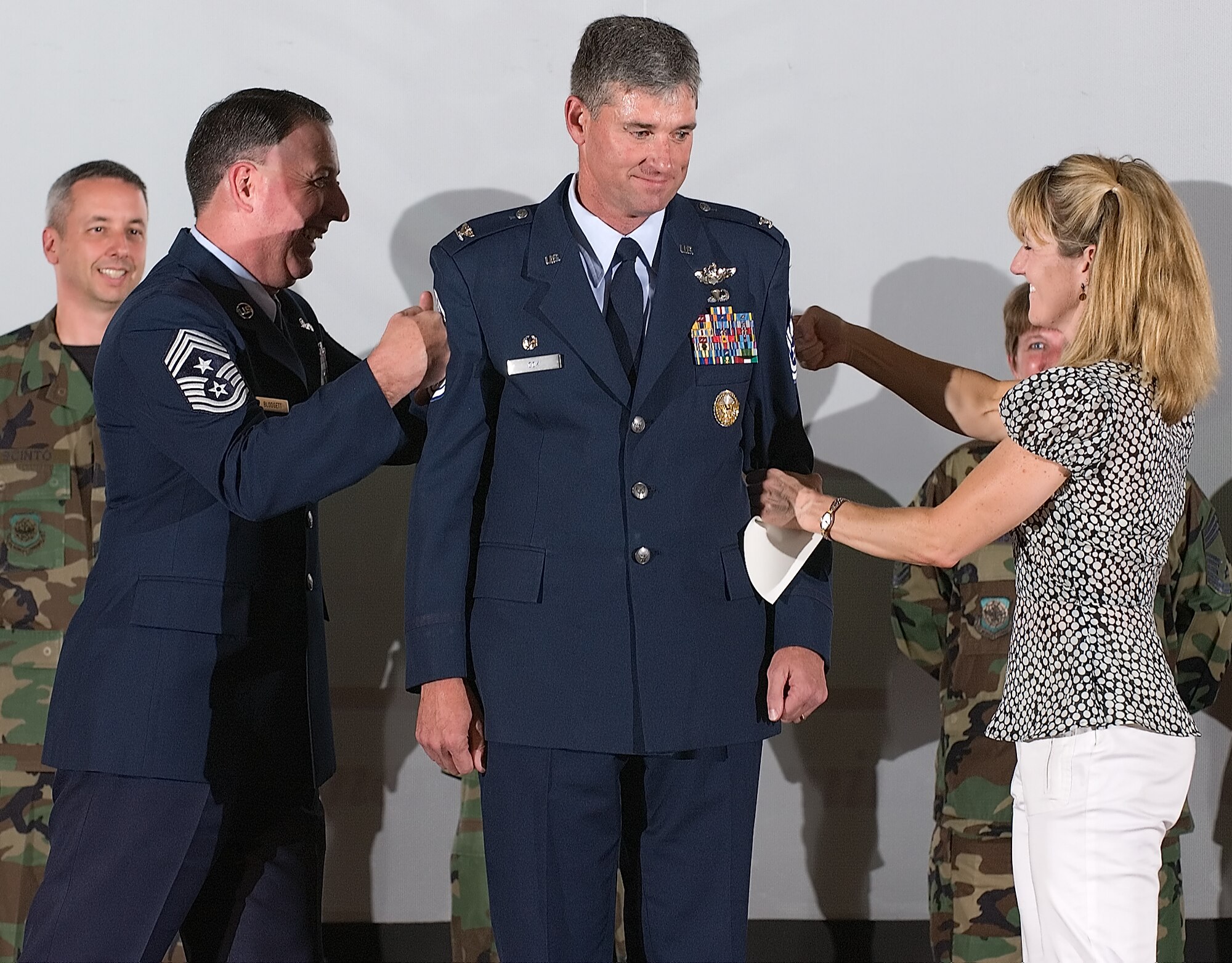 DOVER AIR FORCE BASE, Del. -- Col. Sam Cox, 436th Airlift Wing commander, has a set of honorary chief master sergeant stripes tacked on by his wife, Tammy, and Chief Master Sgt. Bruce Blodgett, 436th AW command chief, during Monday’s wing promotion ceremony. (U.S. Air Force photo/Jason Minto)
