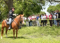 DeWayne Henderson, manager of the Lackland Saddle Club at Lackland Air Force Base, Texas, is mounted on his horse, Risky, explaining the Civil War uniform and Soldier's life during the war, to the Defense Language Institute English Language Center staff and faculty, AMIGO Sponsors and international students present. The break from the classroom allowed the students to use their new English skills to communicate with picnic attendees. The DLIELC is responsible for teaching English to international military and civilians from more than 90 allied countries.  The second mission, through the Field Studies Program Division, is to present the American culture in all its aspects. (USAF photo by Robbin Cresswell)