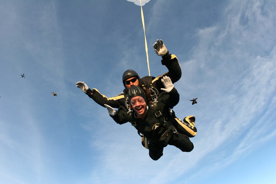 Melissa Bunting, an executive producer for Tampa, Fla., radio station WTBT 103.5 FM, freefalls over nearby MacDill Air Force Base April 26 during a tandem jump with Sgt. 1st Class Michael Elliott of the U.S. Army Golden Knights Parachute Team.  The pair jumped from an Air Force Special Operations Command CV-22 Osprey, far left, from the 8th Special Operations Squadron at Hurlburt Field, Fla. (Department of Defense photo)