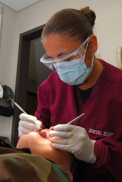 Staff Sgt. Meriles Curry, 23rd Aeromedical Dental Squadron dental technician, performs a tooth cleaning at the Moody Air Force Base Dental Clinic May 2.  Sergeant Curry was recently selected for the two-year Air Force Dental Hygiene Training Scholarship Program at Trident Technical College in Charleston, S.C. (U.S. Air Force photo by Tech. Sgt. Parker Gyokeres)