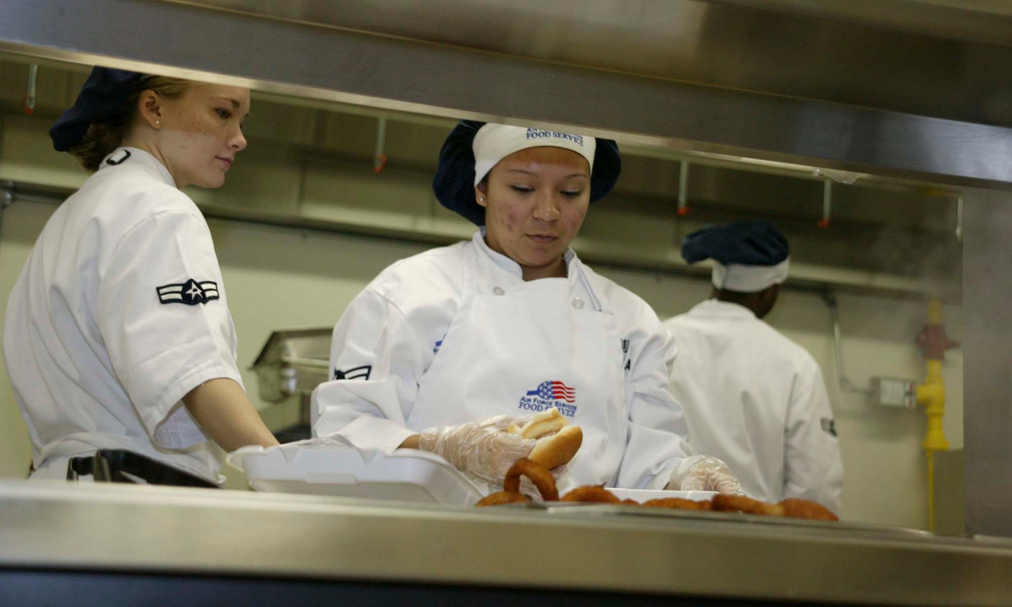 SHAW AIR FORCE BASE, S.C. -- Airmen 1st Class Heather Krump (left) and Edna Padilla, 20th Services Squadron food service specialists, prepare lunch May 1 in the new flight kitchen in the Chandler Deployment Processing Center. The flight kitchen is open 11 a.m. to 1 p.m. and 4:30 to 7 p.m. Monday through Friday.  It will not be open during the Phase II exercise in May. (U.S. Air Force photo/ Senior Airman Holly MacDonald)  