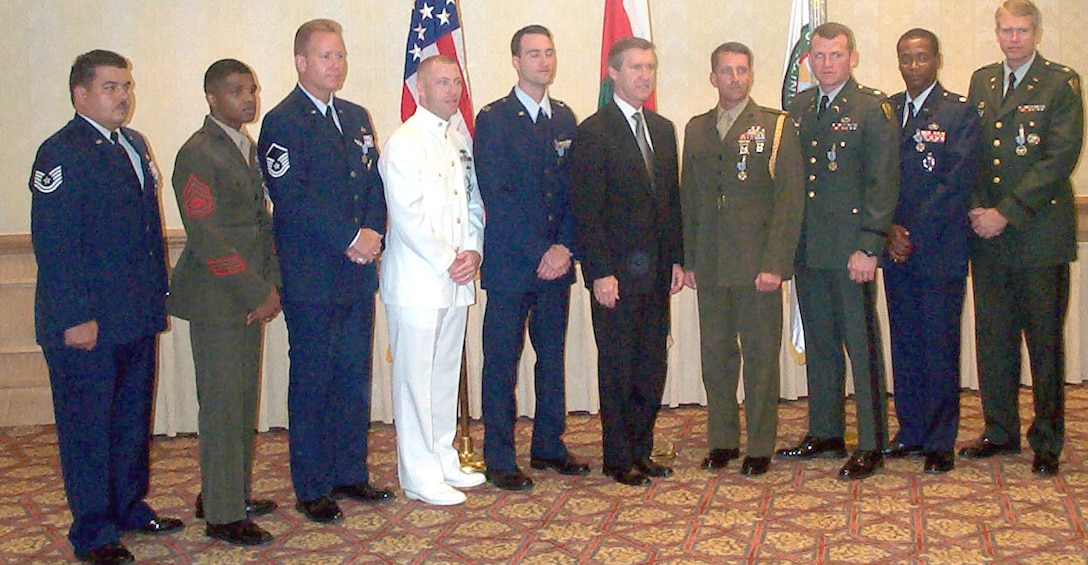 Air Force Tech. Sgt. Dennis Connolly (from left), Marine Corps Gunnery Sgt. Alonzo Woolery, Air Force Master Sgt. William Holland, Navy Chief Petty Officer Mark Shafer, Air Force Capt. Jeffery Moody, Secretary of Defense William Cohen, Marine Corps Maj. Stephen Gorzynski, Army Lt. Col. Robert Felkel, Air Force Lt. Col. Eric Brooks, and Army Col. Rodger Oetjen pose for the camera Nov. 17 in Oman.