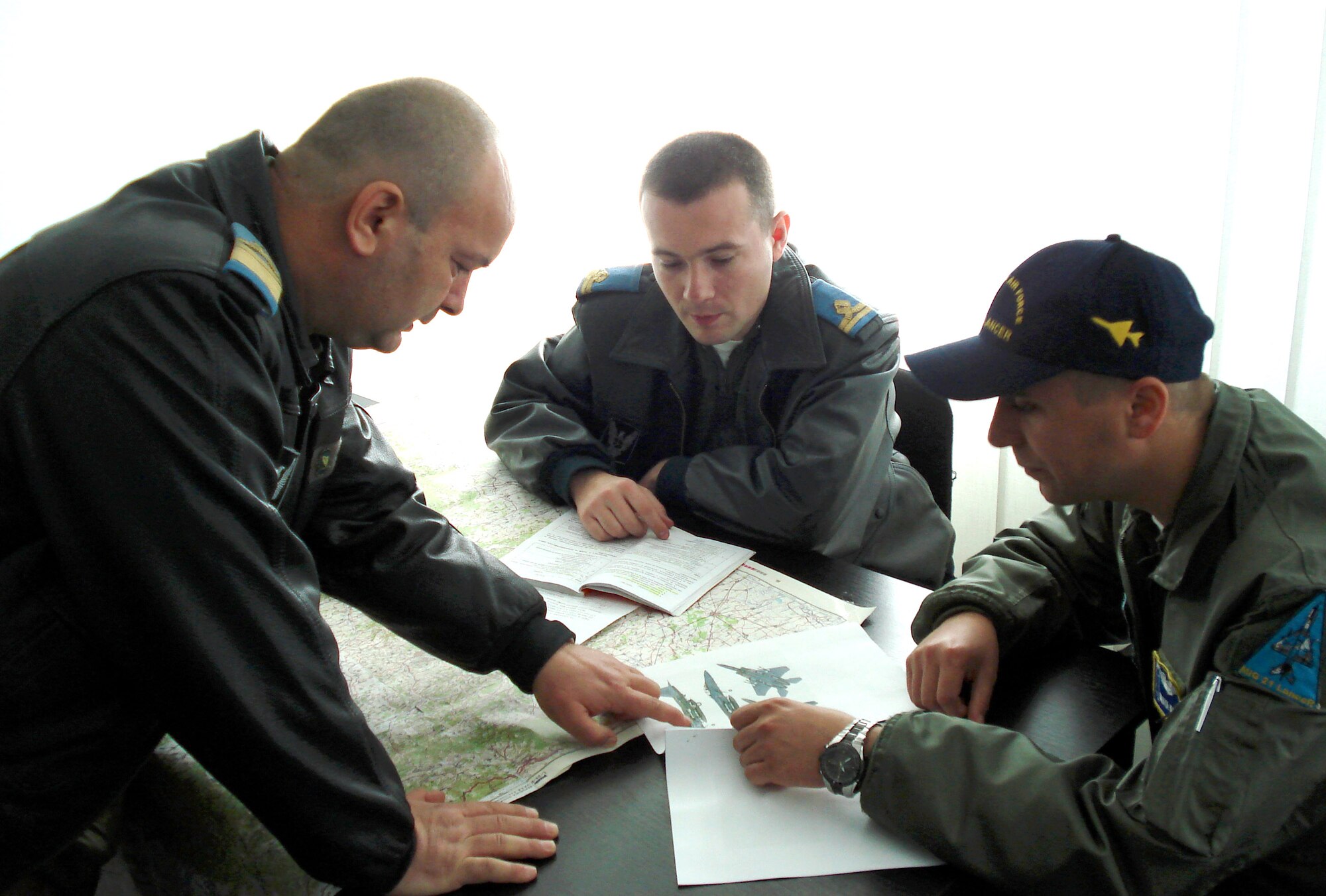 Captain Commander Dobre Constantin and First Lieutenants Mihaita Marin and Radu Paraschiv discuss F-15C and MIG 21 flight paths during Sniper Lance 2007, an exercise with more than 200 Airmen from United States Air Forces in Europe. The exercise, which includes Romanian MIG-21s from the nearby 86th Air Base, F-15Cs from Royal Air Force Lakenheath and KC-135s from RAF Mildenhall ends May 4. (U.S. Air Force photo/Capt. Jamie Humphries)