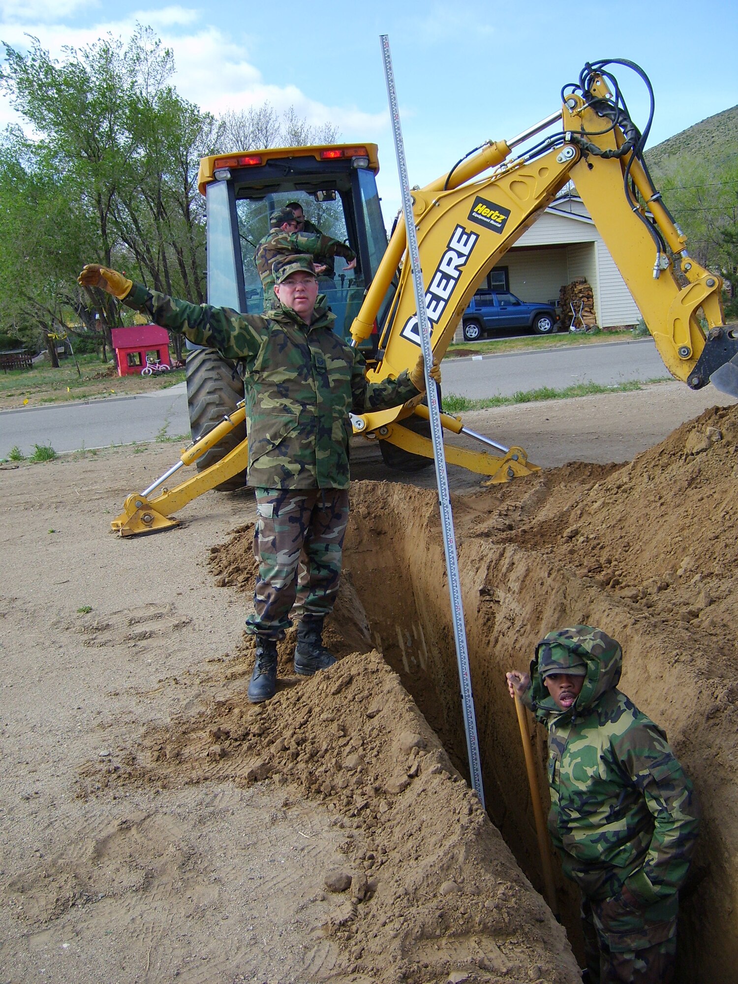 CARSON CITY, Nev. -- Master Sgt. Stepfan Berrier signals to a surveyor while measuring the depth of a sewage line trench on May 3, 2007. He was among 24 reservists from Dobbins Air Reserve Base, Ga., who performed their annual tour at Carson City as part of the Department of Defense's Innovative Readiness Training program. Every two weeks a new CE unit rotates through this site to complete civil engineering projects for the Washoe Tribe. Similar training takes place at several sites throughout the U.S. each year. (U.S. Air Force photo/Phil Rhodes)