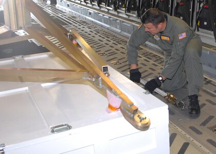 BUCKLEY AIR FORCE BASE, Colo. -- Staff Sgt. Mike Morris, a loadmaster with the 16th Airlift Squadron from Charleston Air Force Base, S.C., secures support equipment for NASA's Phoenix Mars Lander in a C-17 here May 7. The lander, which was built at Lockheed Martin Space Systems Company's Waterton Canyon facilities in Littleton, Colo., was loaded on a C-17 for transportation to NASA's Kennedy Space Center in Florida for final test and launch preparations. The Phoenix lander is slated for liftoff aboard a Delta II launch vehicle in early August. (U.S. Air Force photo by Airman 1st Class Alex Gochnour)