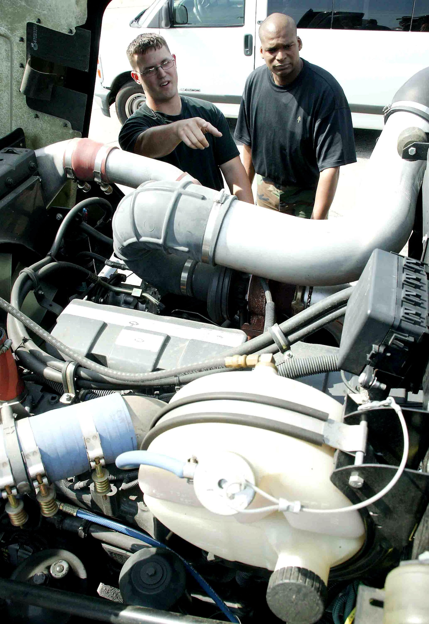 Staff Sgt. Stephen Zuelke (left) and Tech. Sgt. Spellmon Quinn discuss the location of the fuse box on an R-11 hybrid refueling vehicle April 25 at Shaw Air Force Base, S.C. The 72,000-pound, environmentally-friendly hybrid, the only one of its kind in the Air Force, is undergoing a one-year test at to see how much money it is saves on fuel, maintenance and other cost measurements. Sergeants Zuelke and Quinn are vehicle technicians assigned to the 20th Logistics Readiness Squadron. (U.S. Air Force photo/Senior Airman John Gordinier)