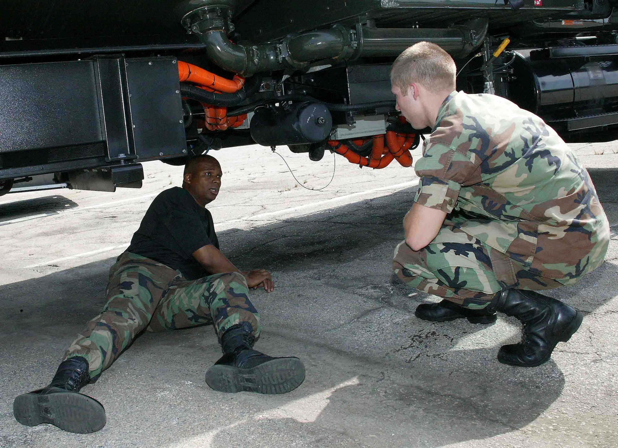 Tech. Sgt. Spellmon Quinn (left) and 2nd Lt. Zachary Buckallew talk about the performance of the electric motor on an R-11 hybrid refueler April 25 at Shaw Air Force Base, S.C. The environmentally-friendly, 72,000-pound hybrid, the only one of its kind in the Air Force, is undergoing a one-year test at Shaw to see how much money it saves on fuel, maintenance and other cost measurements. Sergeant Quinn is a vehicle technician and Lieutenant Buckallew is a maintenance flight commander. Both are assigned to with the 20th Logistics Readiness Squadron. (U.S. Air Force photo/Senior Airman John Gordinier)