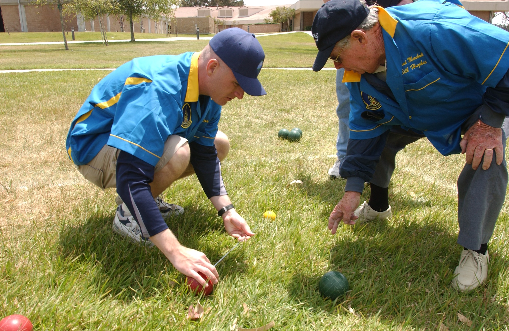Master Sgt. Thomas "O'Malley Factor" O'Malley and referee Bill Huges from the Santa Maria Lawn Bowling Club use a measuring rod to determine whose ball is closer to the pallino, or marker, during the Combat Bocce Ball Tournament here May 4. The event was put on as one of the 381st TRG quarterly events to ensure morale stays high. (U.S. Air Force Photo by Nichelle Griffiths)