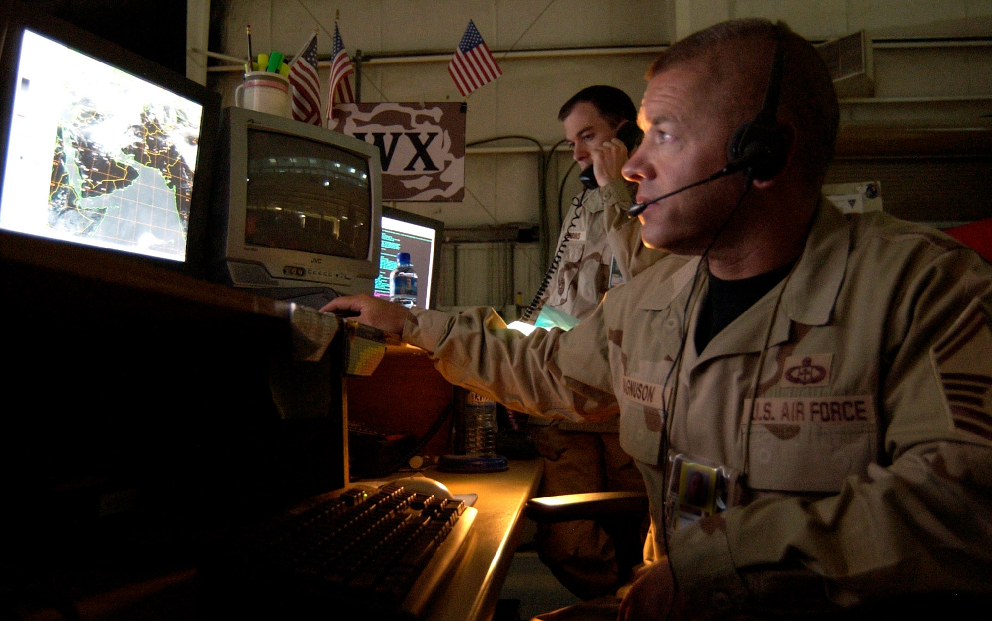 Senior Master Sgt. Brian Magnuson monitors the weather in Southwest Asia's 55-million square mile area of responsibility, while Capt. Bradley Stebbins, (left) coordinates with another weather unit in theater. Airmen with the Combat Operations Division Weather at the Combined Air and Space Operations Center create weather forecasts from information gathered from satellites and forward weather teams. This information provides senior leadership and coalition liaisons the weather picture to enhance warfighting plans. (Courtesy photo)