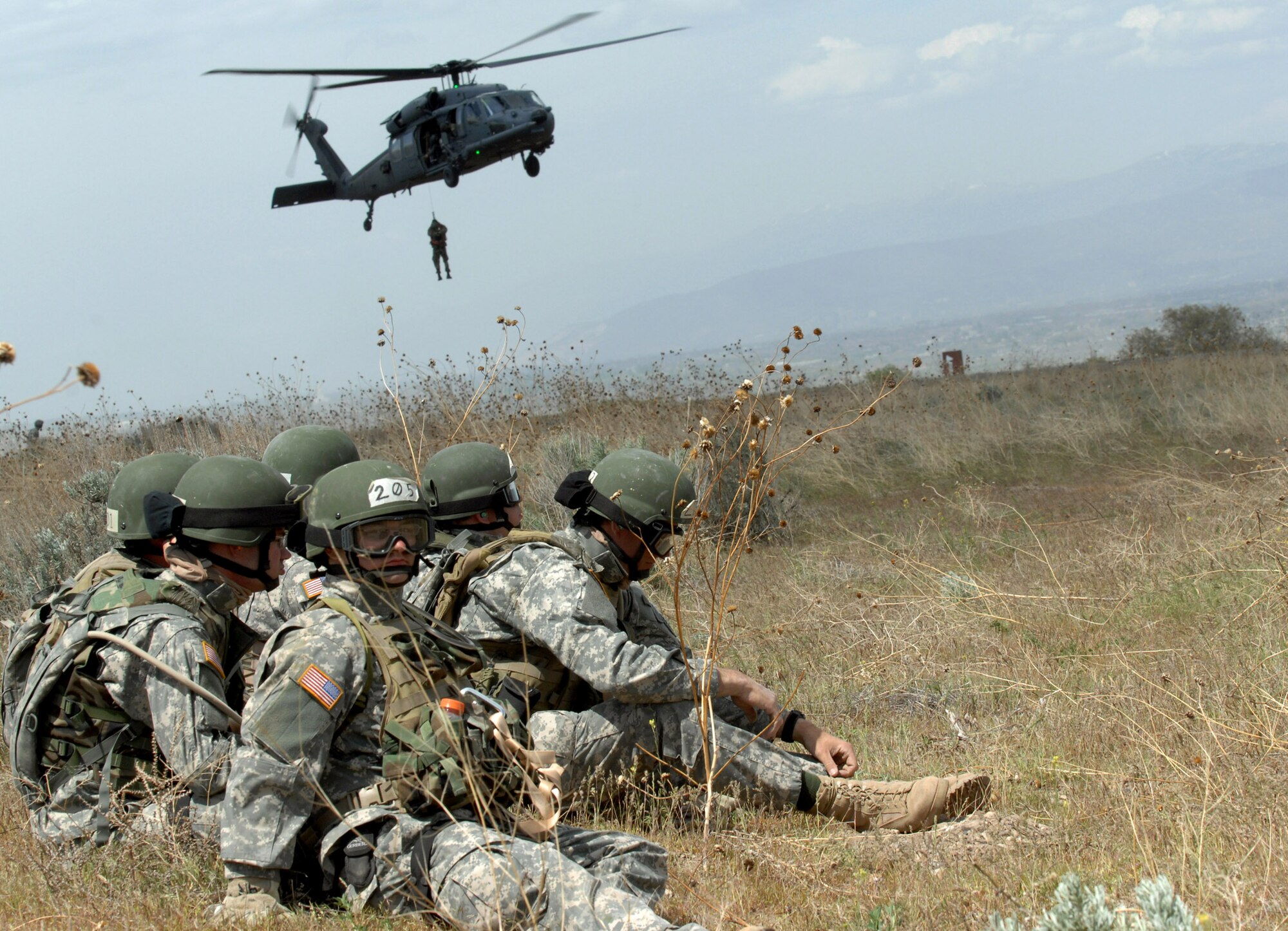 Soldiers from the Utah National Guard unit wait to be hoisted on board an Air Force HH-60 Pave Hawk helicopter over the Utah Test and Training Range during a combat search and rescue integration exercise held May 2 to 5 in Sandy, Utah. Members of the 34th Weapons Squadron Nellis Air Force Base, Nev., led the search and recovery training. The objective of the exercise was to expand expertise and integration with Utah's 211th Aviation Group AH-64 Apache Joint Rotary Wing, 4th Fighter Squadron F-16 Fighting Falcon Striker assets, special operations forces and conduct extensive joint CSAR operations against surface-to-air threats. (U.S. Air Force photo/Master Sgt. Kevin J. Gruenwald) 
