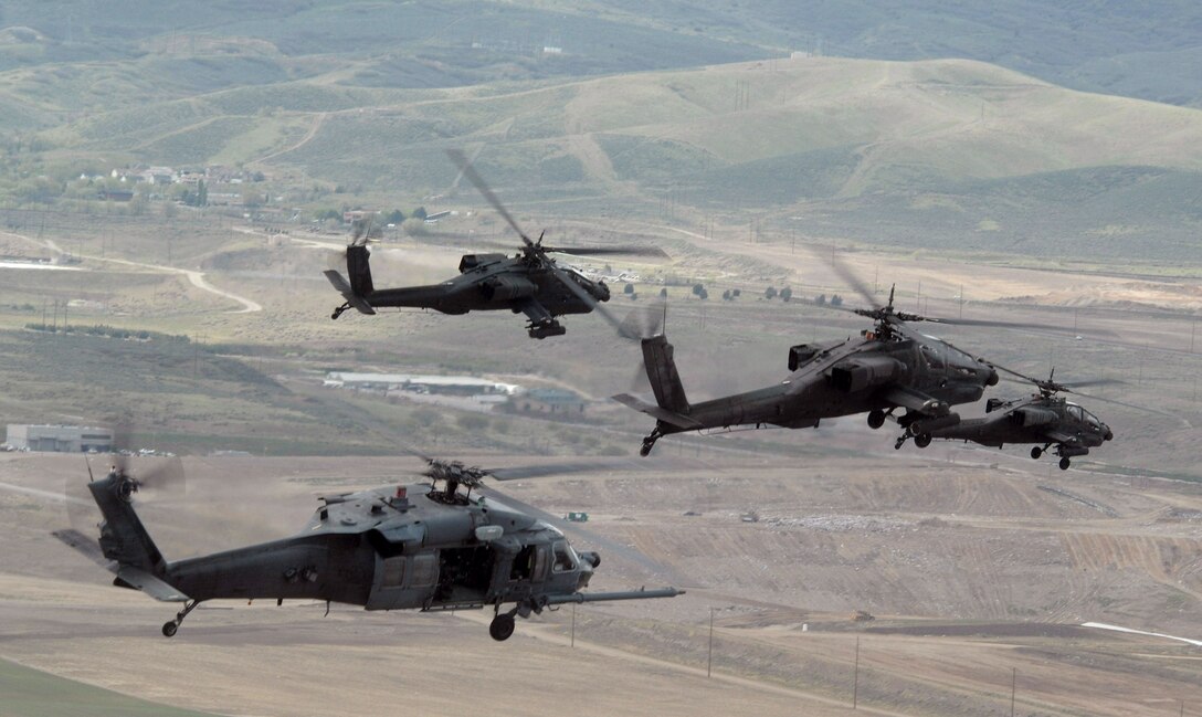 An Air Force HH-60 Pave Hawk (lower left) from Nellis Air Force Base, Nev., heads out to the Utah Test and Training Range with a formation of Army AH-64 Apaches during a combat search and rescue integration exercise held May 2 to 5 in Sandy, Utah. Members of the 34th Weapons Squadron from Nellis AFB led the search and recovery training. The objective of the exercise was to expand expertise and integration with Utah's 211th Aviation Group AH-64 Apache Joint Rotary Wing, 4th Fighter Squadron F-16 Fighting Falcon Striker assets, special operations forces and conduct extensive joint CSAR operations against surface-to-air threats. (U.S. Air Force photo/Master Sgt. Kevin J. Gruenwald) 