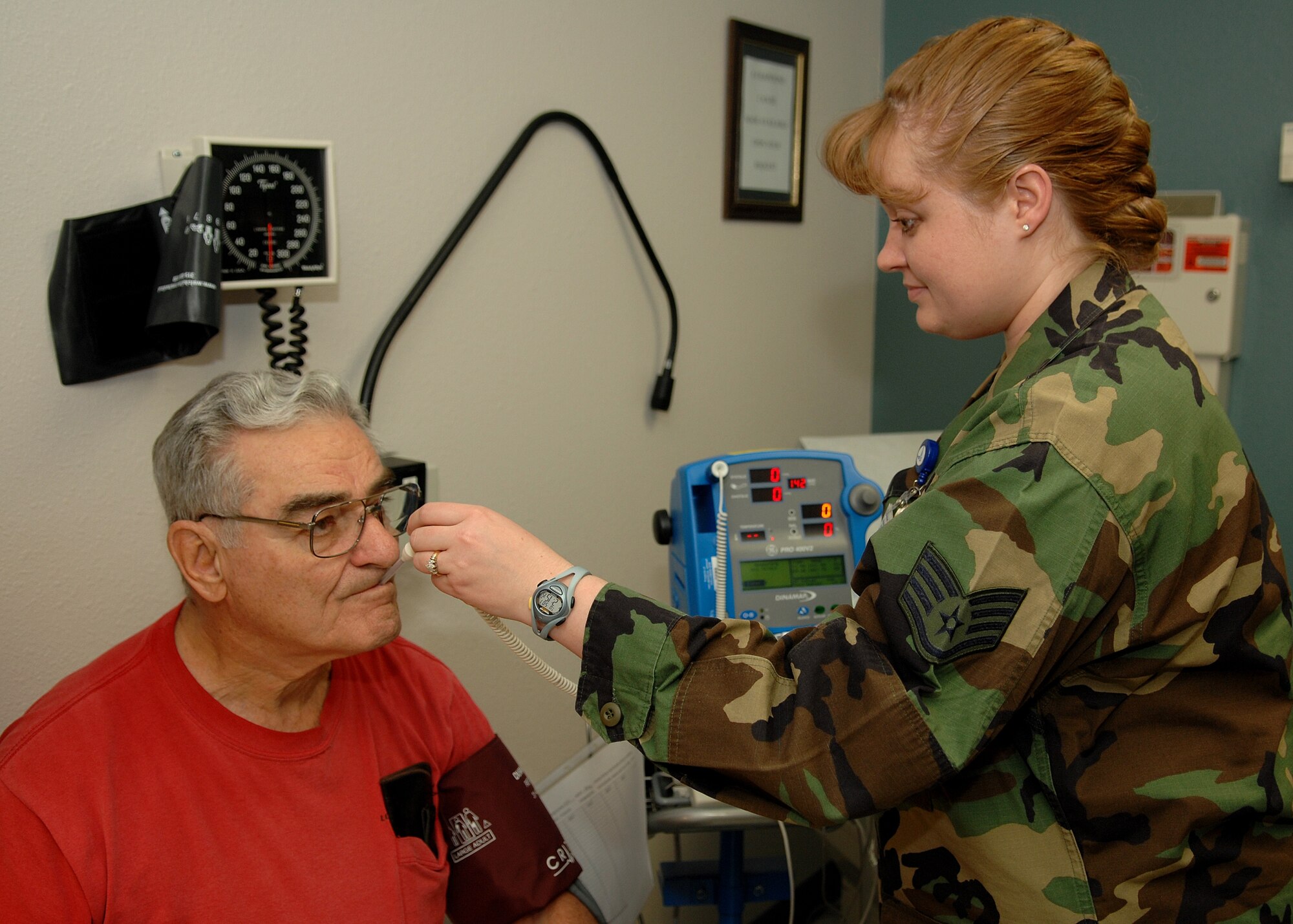 Staff Sgt. Jennifer Pahl, 49th Medical Operations Squadron, takes the temperature of a retiree duriing a routine check up at the Holloman medical clinic. The nursing services staff in the medical clinic are being recognized May 6-12 for National Nurses Week for the job they do on a daily basis. (U.S. Air Force photo by Airman 1st Class John Strong)